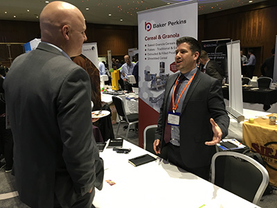 exhibitor speaking to booth visitor at annual meeting 